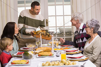 Man serving and showing roast turkey at christmas
