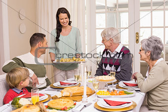 Woman serving christmas dinner to her family