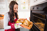 Smiling woman taking out her roast turkey