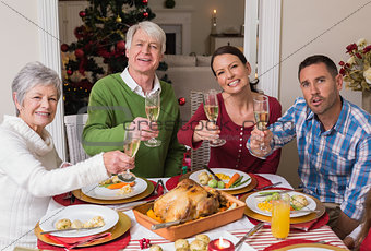 Happy family toasting at camera during christmas dinner