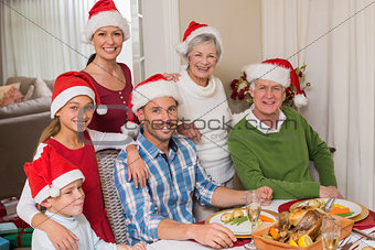 Happy extended family in santa hat looking at camera