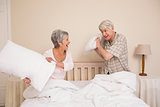 Senior couple having a pillow fight