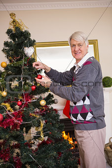 Senior man decorating the christmas tree