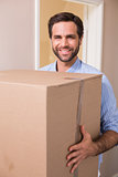 Happy man carrying moving box
