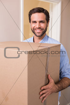 Happy man carrying moving box