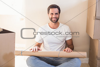 Happy man sitting surrounded by boxes