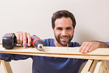 Casual man drilling nail in plank