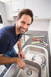 Plumber fixing sink with screwdriver
