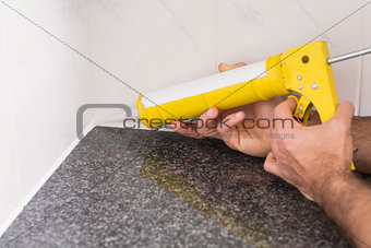 Plumber putting filling in between tiles