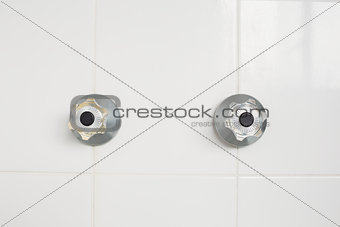 Taps on tiled wall