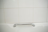 Metal handle in white bath