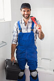 Plumber holding wrench and toolbox