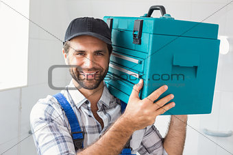 Plumber holding toolbox on shoulder