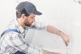 Handyman fixing toilet with screwdriver