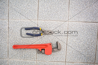 Wrench and pliers on bathroom floor