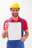 Construction worker showing clipboard to camera