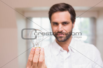 Man showing light bulb to camera
