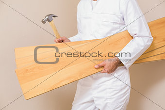 Carpenter holding planks and hammer