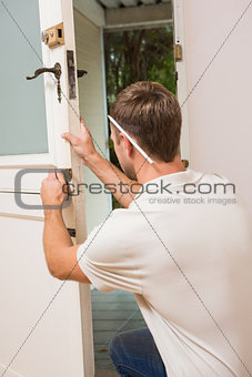 Man fixing locks with screwdriver