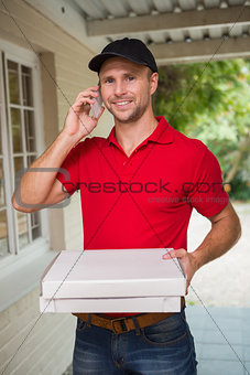 Happy pizza delivery man on the phone