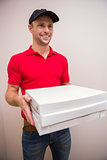 Portrait of happy delivery man holding pizza