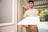 Happy delivery man showing clipboard to sign to customer
