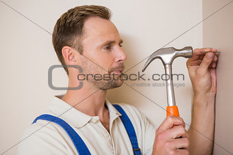 Man hammering nail in the wall