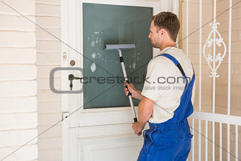 Handyman cleaning the window with squeegees