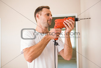 Construction worker drilling hole in wall