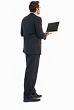 Handsome businessman standing using a laptop