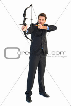 Concentrated handsome businessman practicing archery