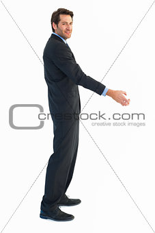 Smiling businessman reaching out to shake hands