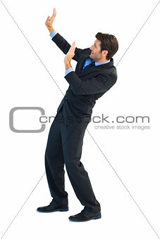 Focused businessman pushing with hands