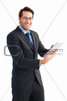 Businessman looking at the camera while using his tablet