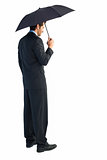 Rear view of classy businessman holding black umbrella