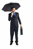 Businessman under umbrella while holding a briefcase