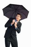 Businessman sheltering with black umbrella