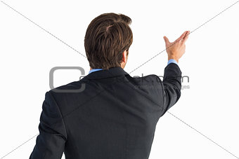 Rear view of young businessman in suit pointing