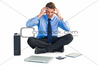 Businessman sitting on the floor with headache