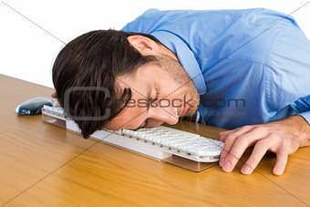 Businessman sleeping with his head on the keyboard