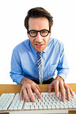 Businessman typing on his keyboard wearing glasses