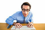 Businessman typing on his keyboard wearing glasses