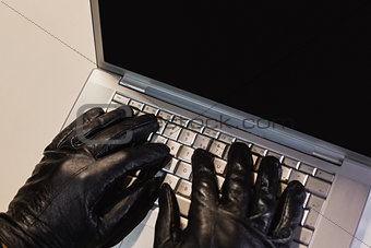 Close up of burglar hacking a laptop