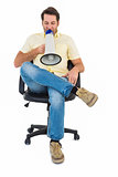 Man sitting on chair shouting through megaphone