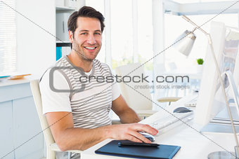 Smiling casual young man using computer