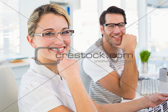Photo editors smiling to the camera with hands under chin