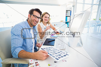 Two happy photo editors working with contact sheets