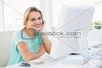 Smiling creative businesswoman posing holding her head