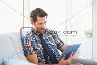 Casual man using tablet on the couch