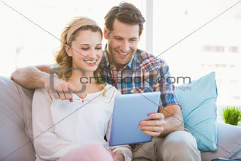 Young couple using tablet pc on the couch